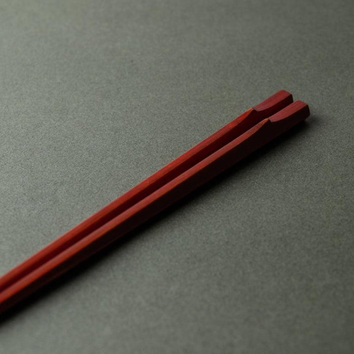 Red hexagonal bamboo chopsticks with Wakasa lacquer finish on grey surface | Matsukan, Japan