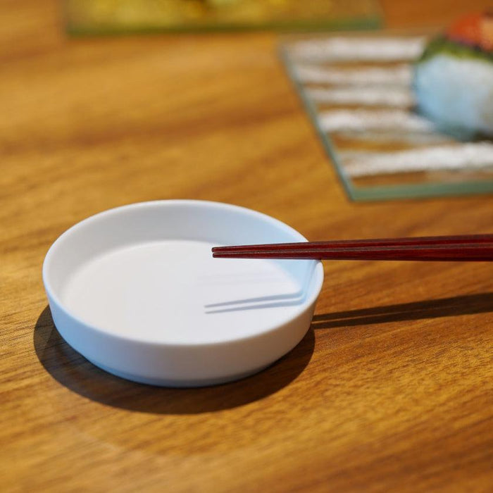 Red Wakasa lacquered chopsticks resting on a small white ceramic dish at a Japanese table setting | Matsukan