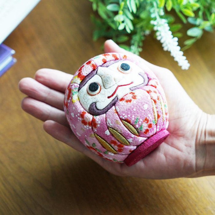 Pink chirimen fabric daruma doll held in palm, floral kimono textile, Edo craft | Japan, Kakinuma Dolls