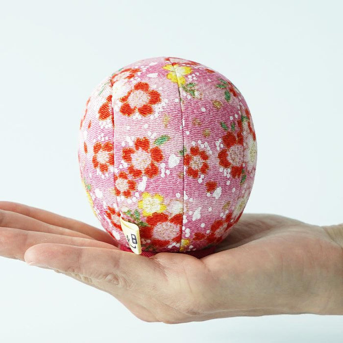 Pink chirimen temari-style ball with floral pattern balanced on an open palm | Edo art dolls, Kakinuma Dolls