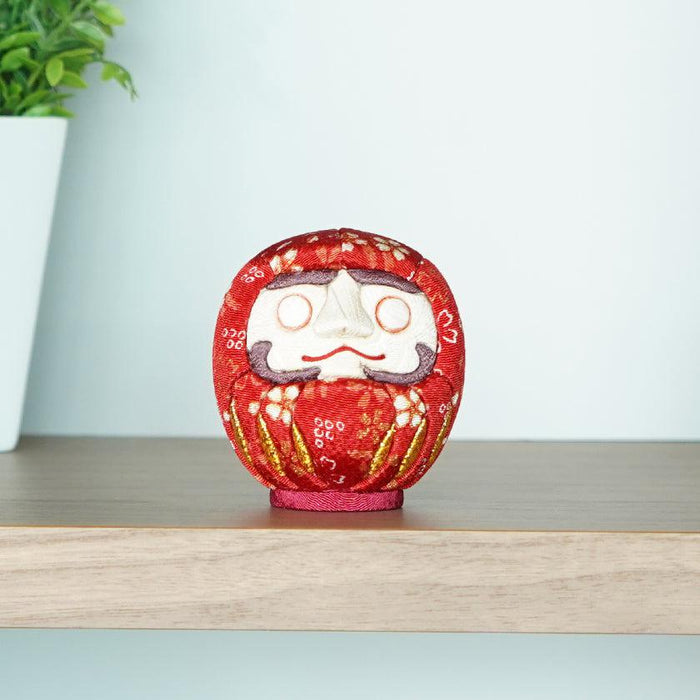 Red chirimen fabric Daruma doll on a wooden shelf | Edo art dolls, Kakinuma Dolls