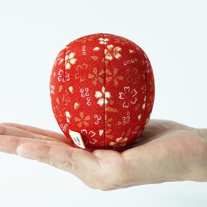 Red chirimen fabric ball with sakura pattern held in a palm | Edo art dolls, Kakinuma Dolls