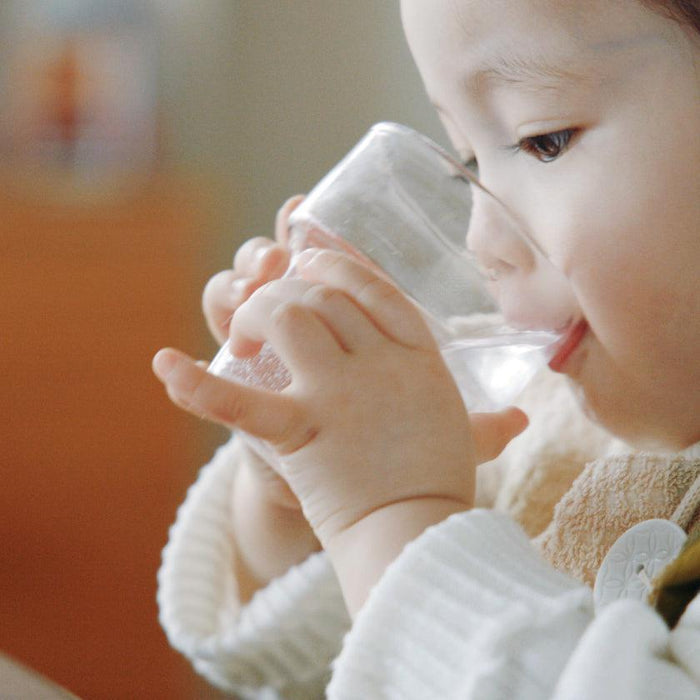 Child drinking from a small Ryukyu glass cup | Okinawa, aeru