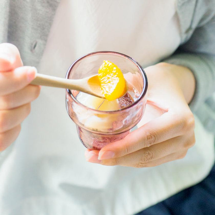Ryukyu glass tumbler held in hands with orange slice and wooden spoon | Okinawa, aeru