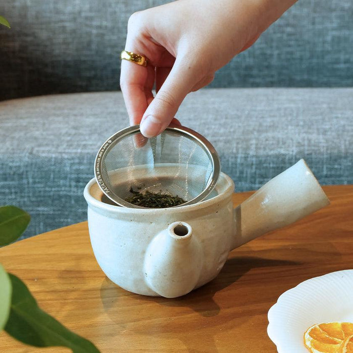 White Shigaraki ware kyusu teapot with mesh strainer being loaded with green tea leaves | Shigaraki, Yamasho Touki
