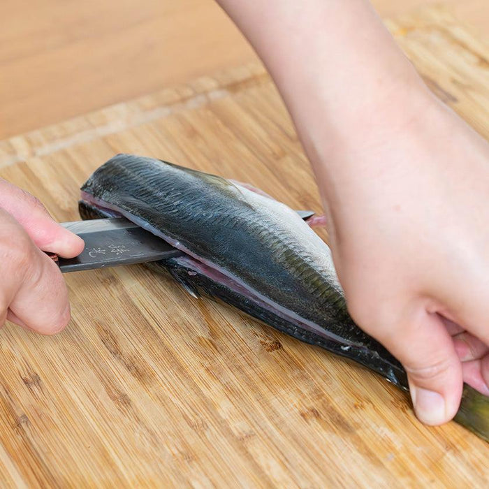 Deba knife filleting a whole fish on a wooden cutting board | Nokaji Blades, Fukube Kaji, Ishikawa