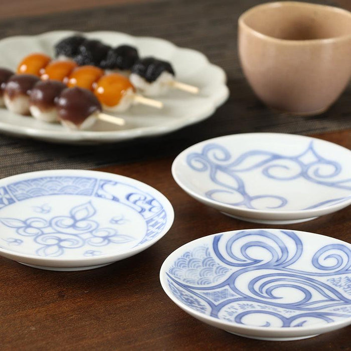 Blue and white dyed ceramic small plates with floral scroll patterns, table setting with Japanese sweets | CIKARPE AKAN