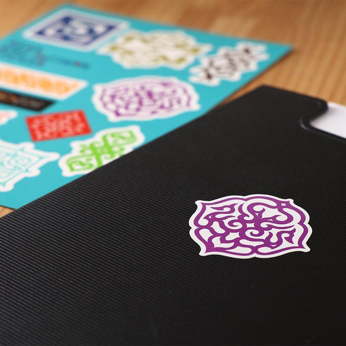 Ainu pattern sticker sheet with colorful designs, one purple sticker applied to black surface | Hokkaido, CIKARPE AKAN