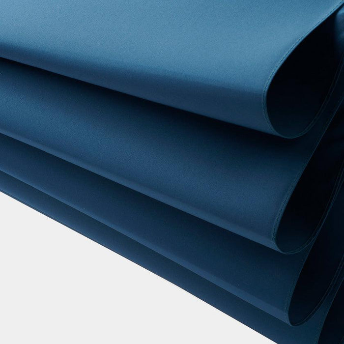 Stacked sheets of deep navy blue fabric material, umbrella cloth close-up